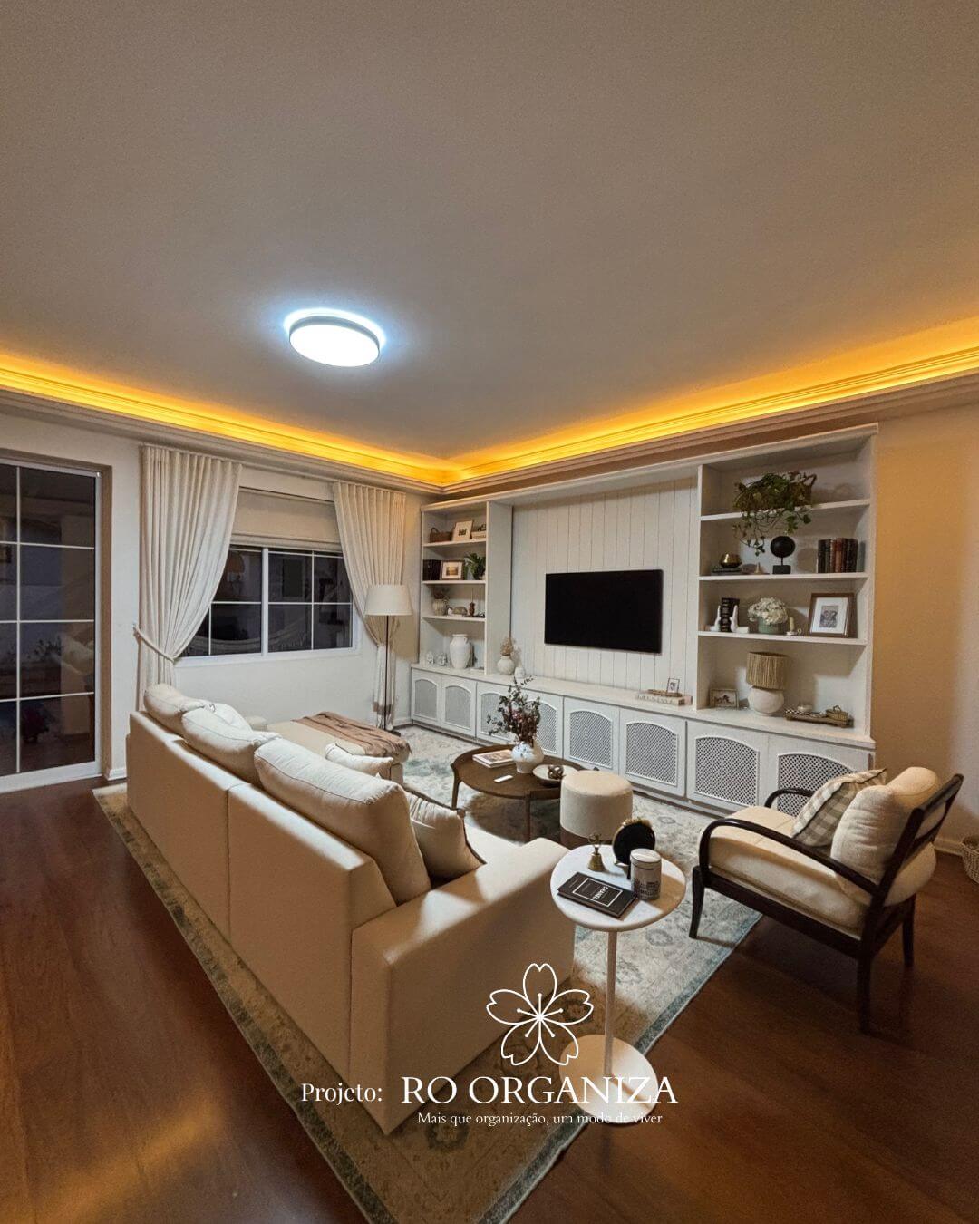 Sala de estar com móveis planejados, TV integrada e iluminação indireta