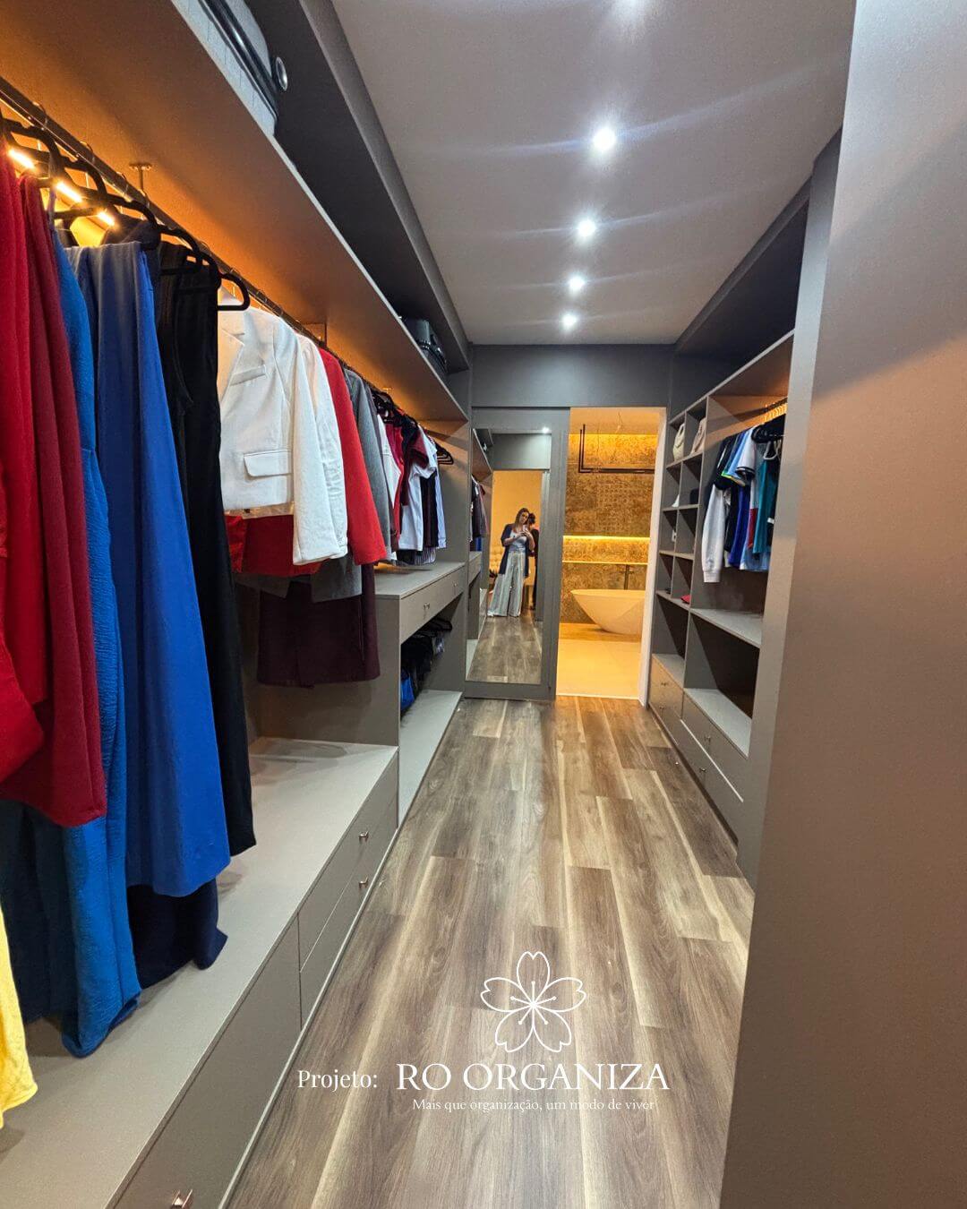 Walk-in closet com roupas organizadas por cores e iluminação LED