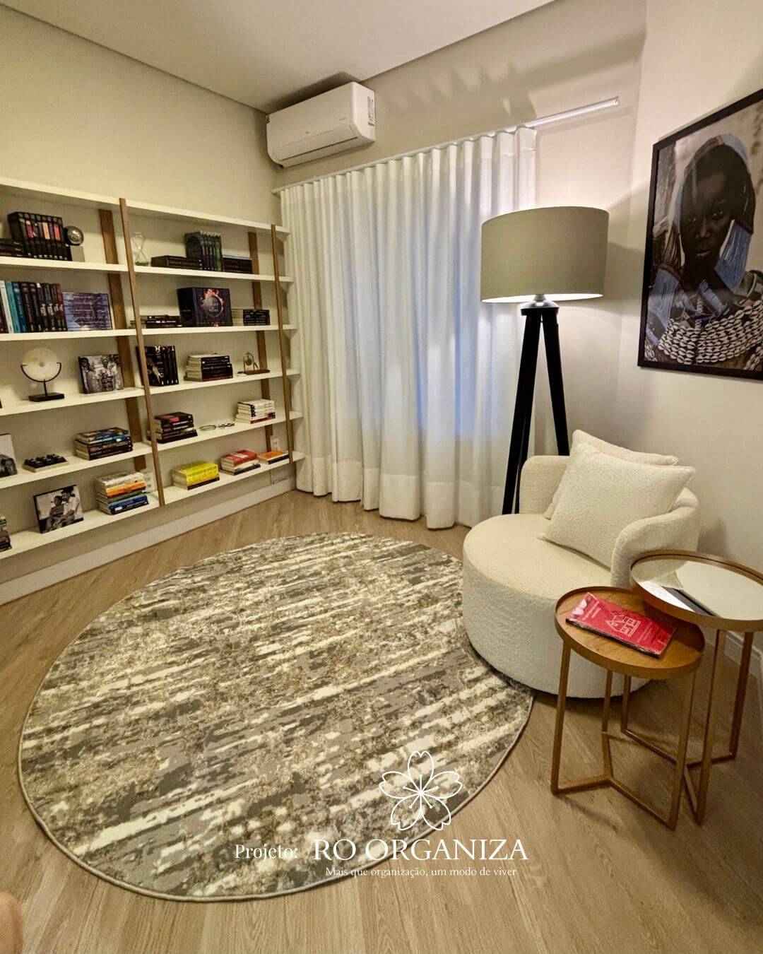 Biblioteca e escritório organizado com estantes, poltrona branca e decoração elegante