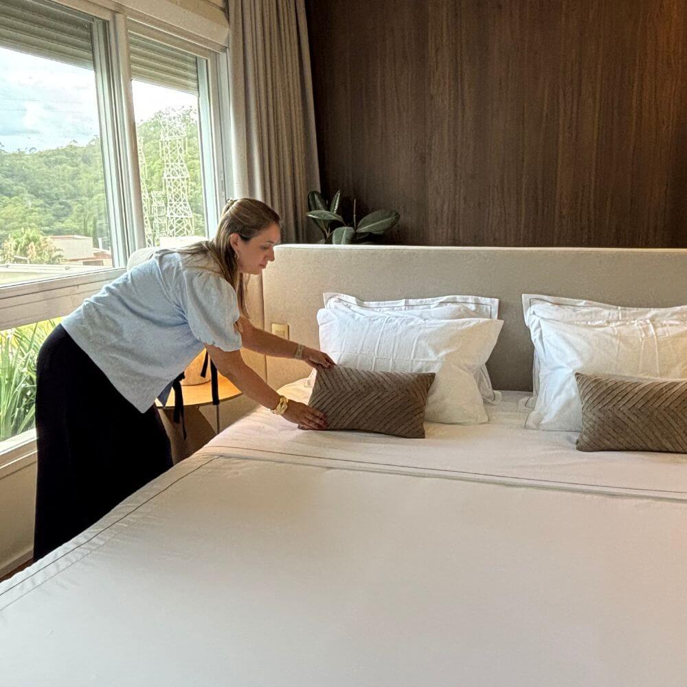 Personal organizer arrumando quarto com cama organizada e ambiente harmonioso